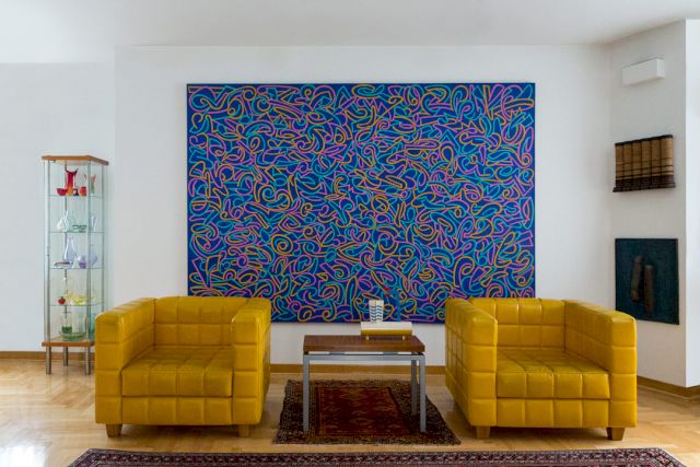 Bora Iljovski, ’Personal Escort’, 1981; (on table) Dušan Otašević, ’Drink’, 1967; (on wall, top) Tomislav Kauzlarić, ’Research with a newspaper’, 1979; (on wall, bottom) Kosta Bogdanović, ’Relief from the cycle Vizanteme’, 1989. Courtesy Kolekcija Trajković; Belgrade, Serbia