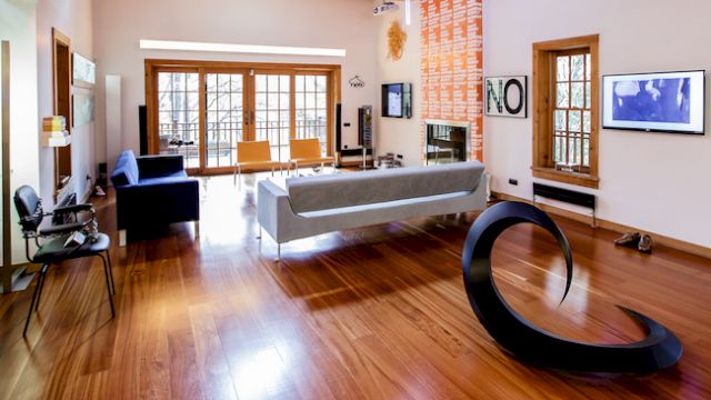 Living room in the house. The digital work above the balcony doors is “Day” by Cevdet Erek. The orange banner on the fireplace is by James Richards. Photo: courtesy of Agah Uğur