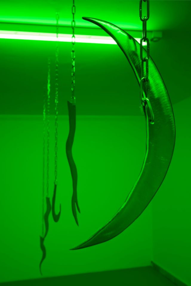 Tarek Lakhrissi, Perfume of Traitors III, 2021–23, Mixed-media installation; eight steel chains, eight steel knives, light-filtering green foil, dimensions variable. Installation view, UNBOUND, JSF Berlin. Photo: Alwin Lay